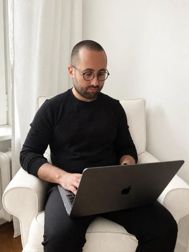 Grzegorz Piekarczyk pracuje na laptopie w fotelu